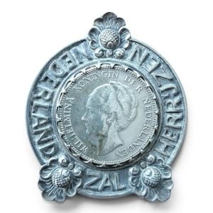 Een broche, vervaardigd van een zilveren gulden van Koningin Wilhelmina in een Djokja zilveren montuur met de tekst 'Nederland zal herrijzen'. In Djokjakarta vervaardigd gedurende de periode dat Nederland bezet was en vóór de Japanse bezetting van Nederlands Indië van 1941. De tekst refereert aan deze uitspraak van Gouverneur-Generaal Van Starkenborch Stachouwer uit mei 1940. Gekeurd met gehalteteken 800. Afmeting 54 x 44 mm